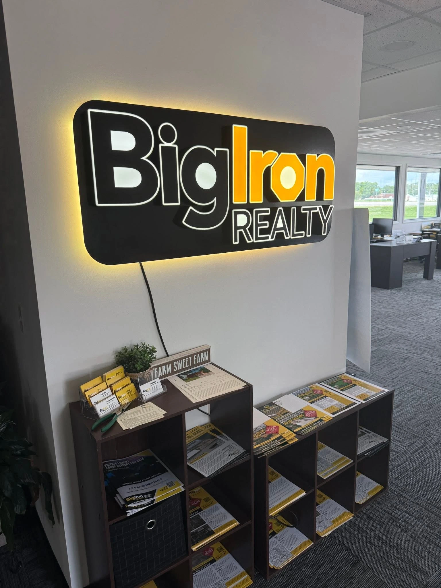 Angled detail of the Big Iron Realty sign and its wall backglow